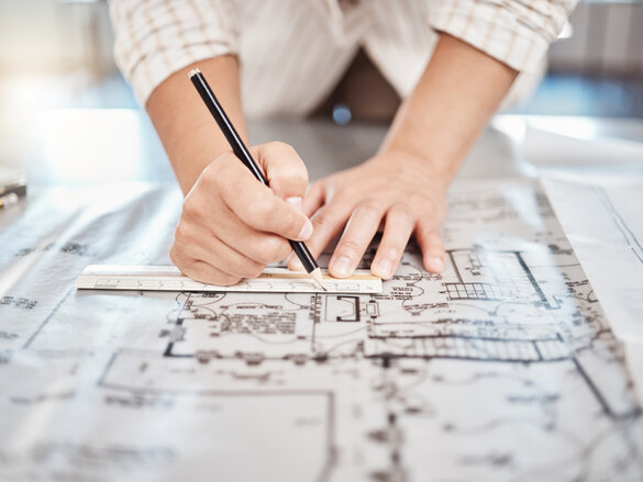 Architect drawing building floor plan, design blueprint map and engineer drafting structure on table paper. Real estate development work office construction and industrial wall safety ruler.