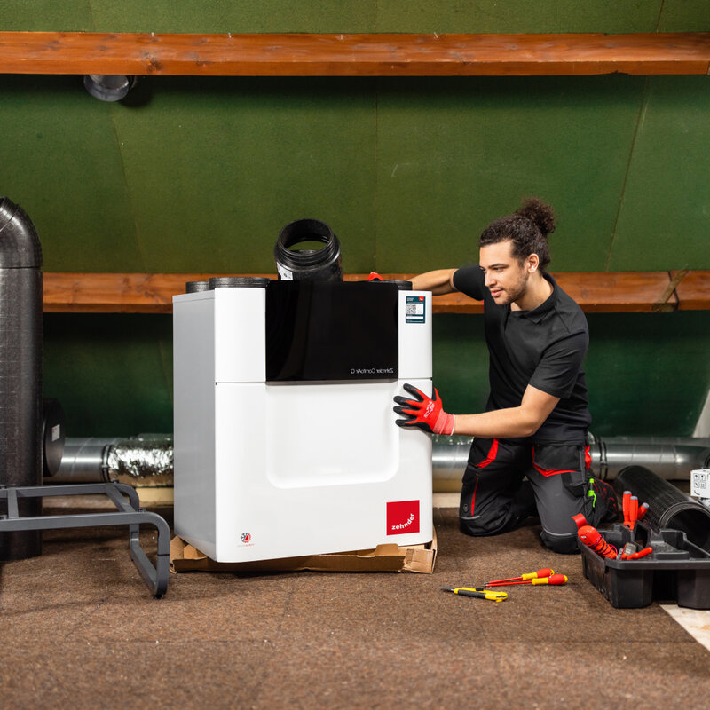 Installer with Comfo Air Q, attic, craftsman, tools, comfo pipe