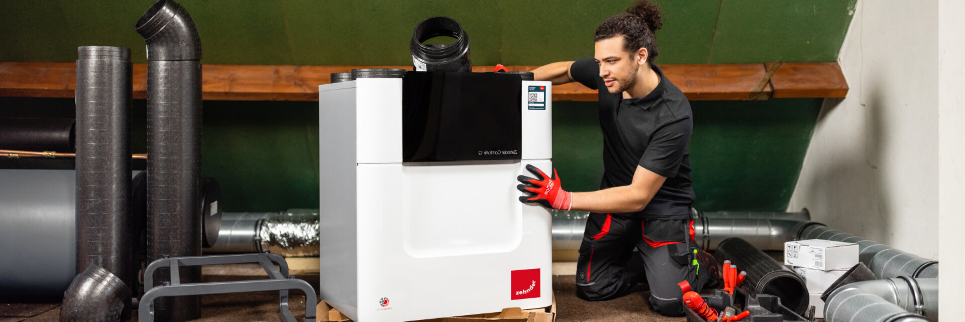 Installer with Comfo Air Q, attic, craftsman, tools, comfo pipe