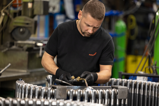 Mitarbeiter bei Zehnder Mann arbeitet mit Charlston-Heizkörper von Zehnder