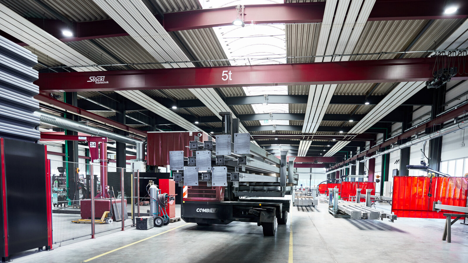  Deckenstrahlplatten in Fertigungshalle mit Produkten und Deckenkränen